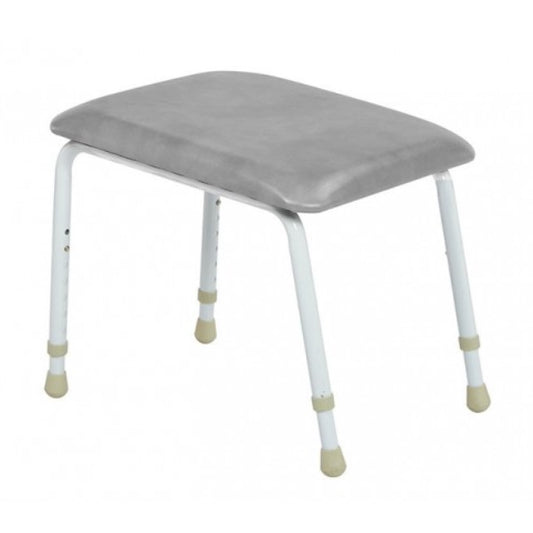 A height adjustable footstool with a gray cushion on a metal frame with plastic caps on the legs from Adaptive Equipment.
