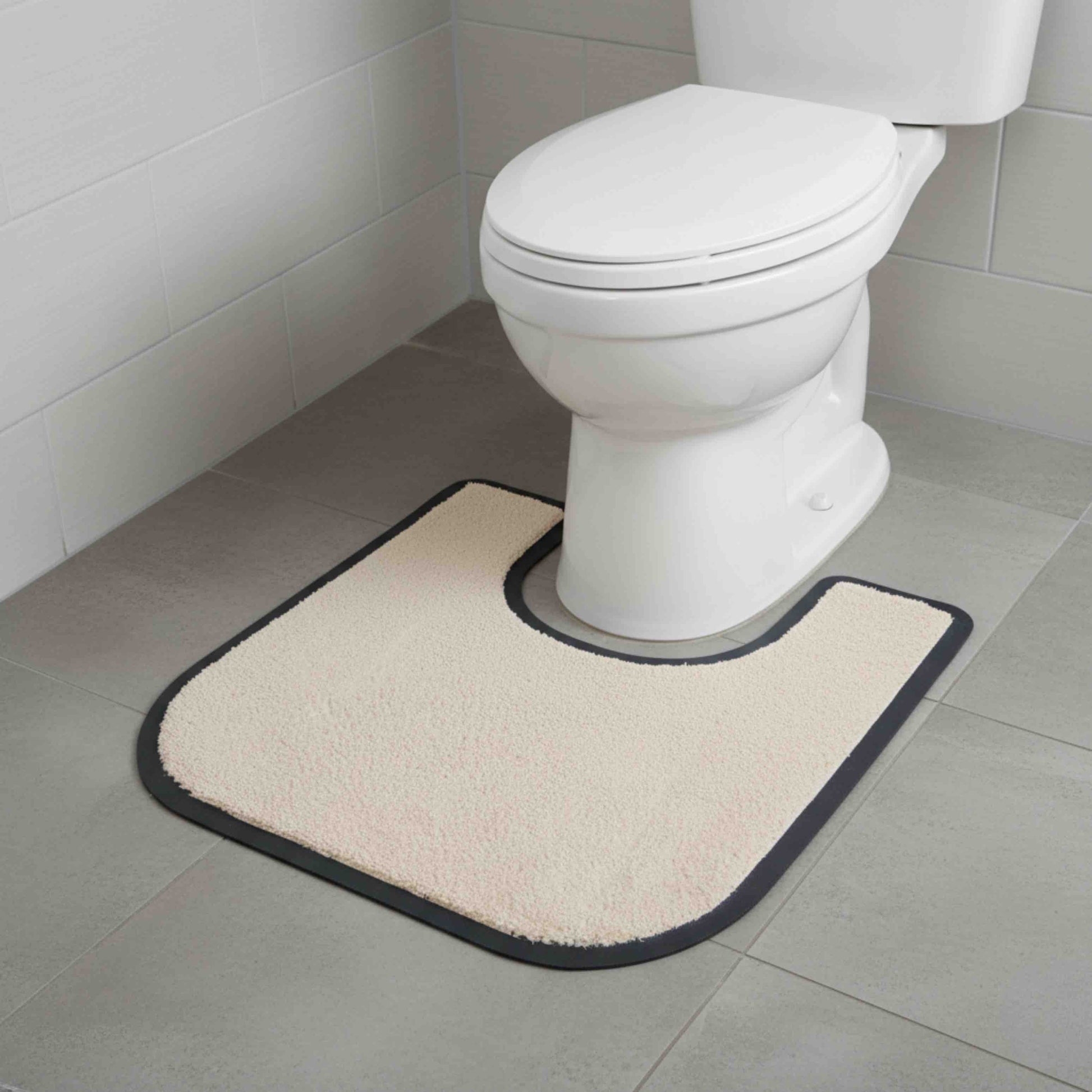 Beige anti-slip toilet surround mat in front of a white toilet on a tiled bathroom floor.
