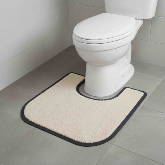 Beige anti-slip toilet surround mat in front of a white toilet on a tiled bathroom floor.