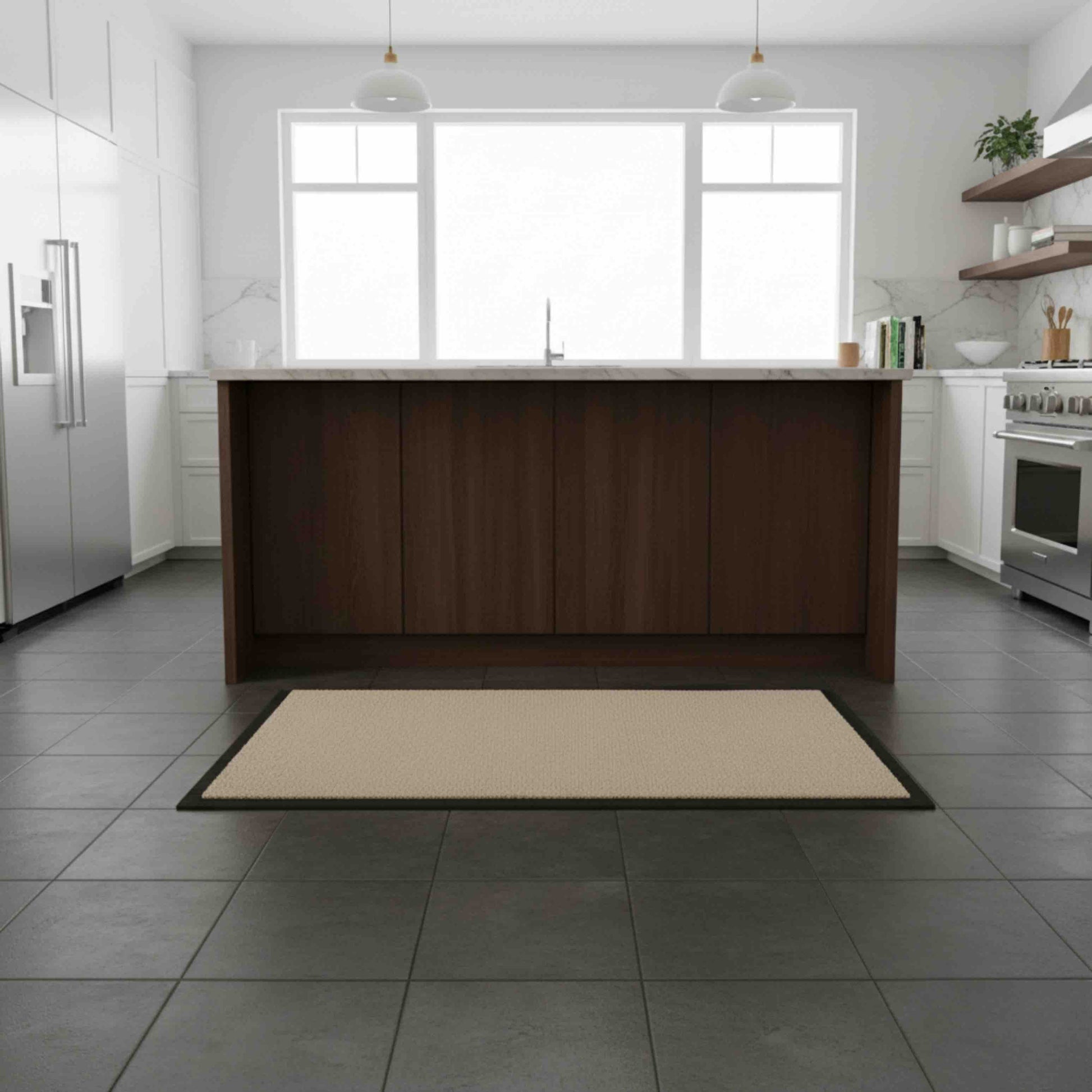 Beige floor anti-slip floor mat on a gray tiled floor in a modern kitchen with wooden island and stainless steel appliances.