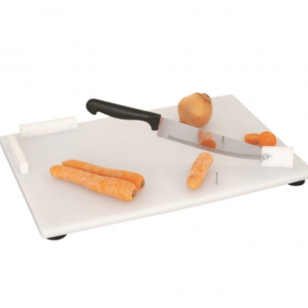 A white cutting board with a chef's knife on it, secured by suction cups. Carrots are also visible on the board, indicating its use for cutting food from Adaptive Equipment.