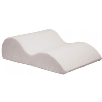 A white foam leg raiser with a soft velour cover, designed to support and elevate legs from Adaptive Equipment.