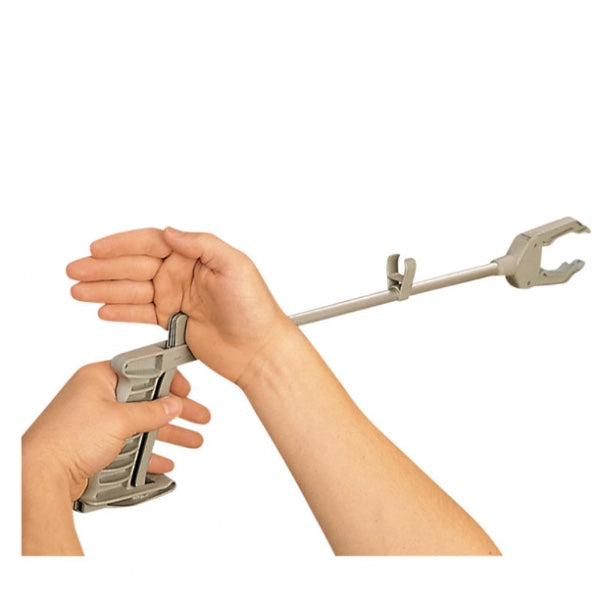A hand holding a silver metal pick-up handy reacher, which is designed to assist with reaching objects.